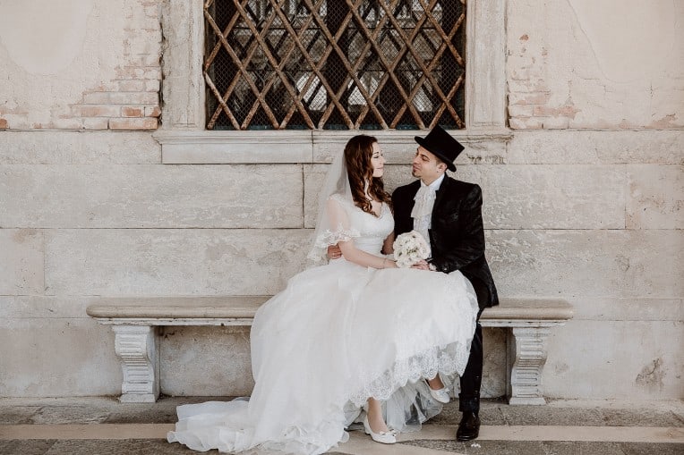 Hochzeitsinspiration "Amore Mio" - Venedig, Brautpaar auf Bank, Bräutigam mit Zylinder | marygoesround.de